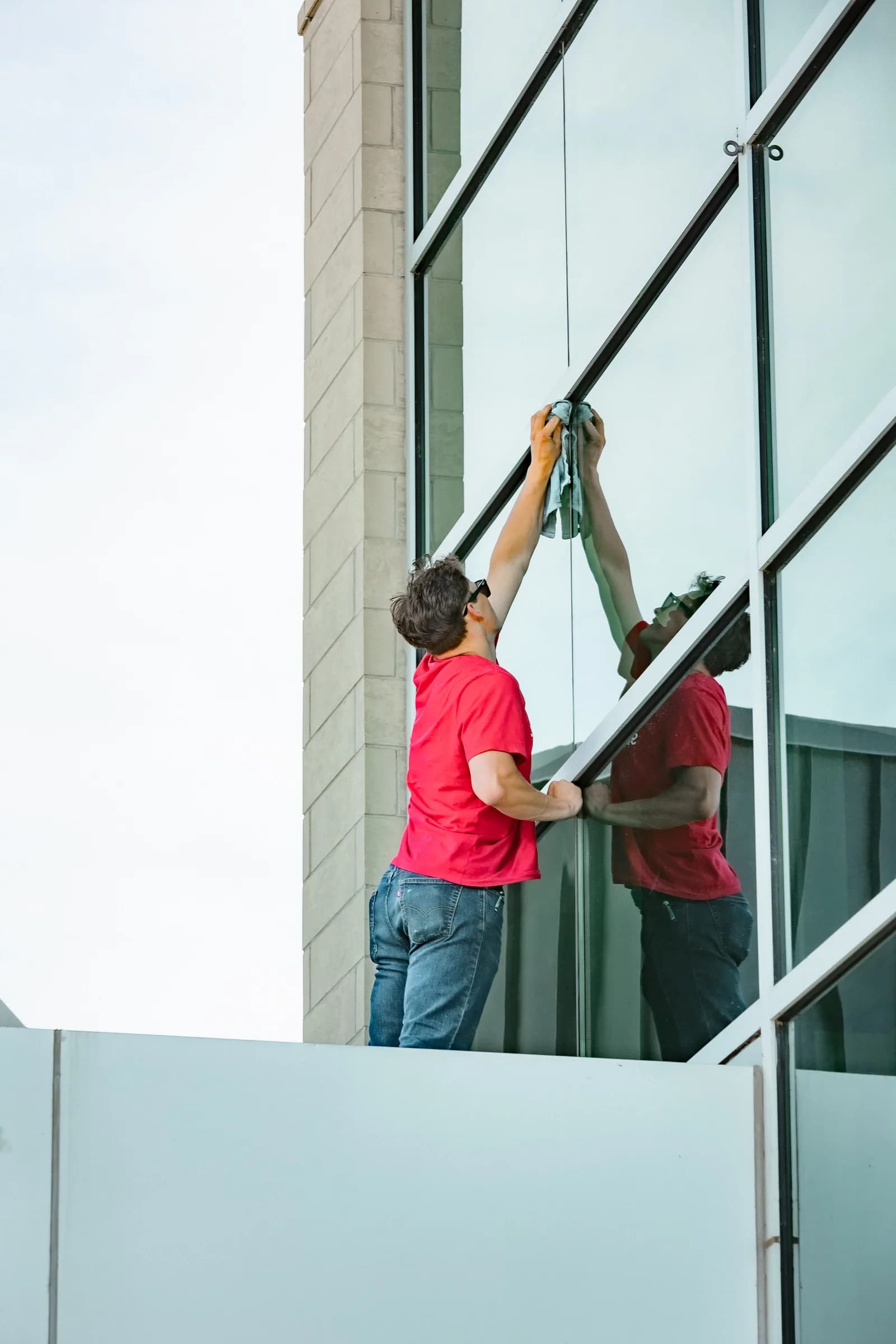 Sonlight technician cleaning glass curtain wall on a commercial building — Greeley, Colorado